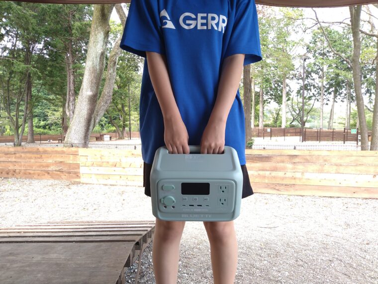 娘がBLUETTI「AORA 30 V2」を両手で持っている様子